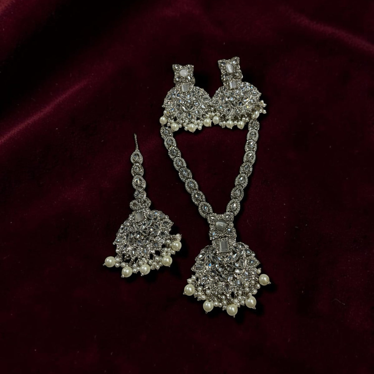 Silver-tone V-neck Kundan necklace set with matching earrings and tikka by Zeywar