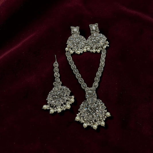 Silver-tone V-neck Kundan necklace set with matching earrings and tikka by Zeywar